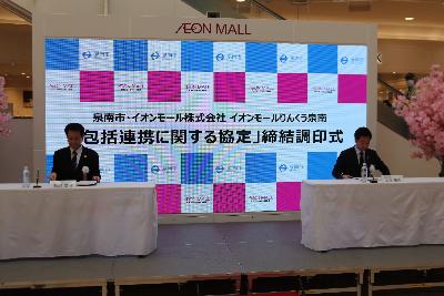 協定書に署名する頼岡GM（左）と山本市長（右）